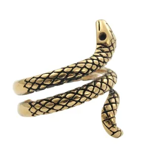 Macro detail showing vintage gold snake ring with realistic scale texture and open design