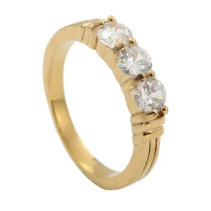 Anillo de boda dorado de tres piedras con textura de líneas paralelas en la banda