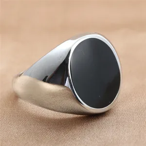 Primer plano de anillo de sello de acero inoxidable con piedra ovalada negra en relieve