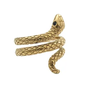Detailed view of golden snake ring with scales and black gemstone eye in punk style
