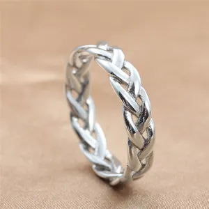 Detailed macro view of silver braided stainless steel ring on brown textured fabric