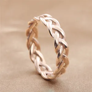 Macro shot of rose gold braided texture ring showing detailed woven design and metal finish