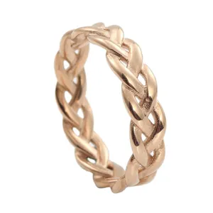 Detail of rose gold braided texture ring showing hollow weave and metallic finish