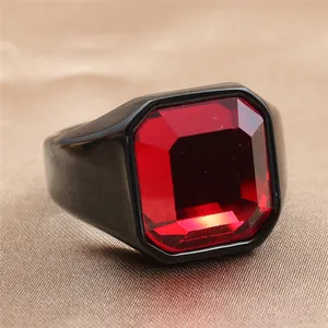 Macro shot of men's vintage black stainless steel ring with a large emerald-cut red stone