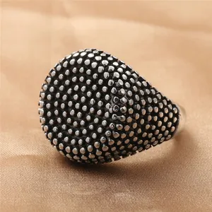Macro-detail van retro roestvrijstalen ring met puntpatroon op gouden zijden stof