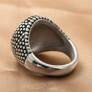 Vintage punk ring van titaniumstaal met stippentextuur op gouden satijnen achtergrond