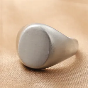 Macro detail of brushed stainless steel oval signet ring with a matte finish on top