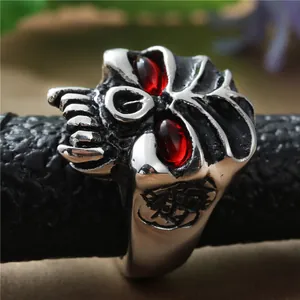 Primer plano de anillo calavera punk plata antigua con ojos rojos y grabado lateral