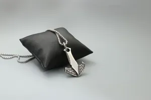 Macro detail of silver pirate hook anchor pendant with vintage textures on a bead chain