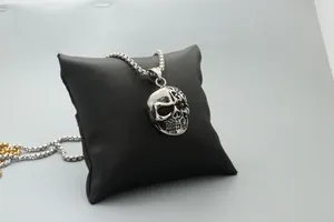 Detail shot of a silver skull pendant necklace with intricate mechanical textures and bead chain