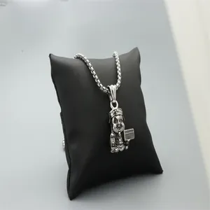 Détail macro du pendentif cochon rétro argenté avec couronne sur chaîne box