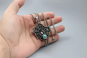 Gros plan du pendentif toile d'araignée avec pierre bleue et finition acier vintage
