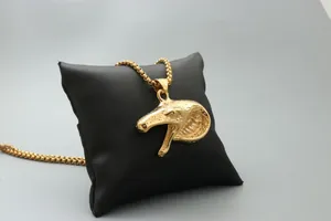 Makroaufnahme von goldener Schlangenkopf-Halskette mit Schuppenstruktur auf Display