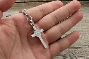 Close-up of silver stainless steel cross pendant featuring INRI engraving and medal detail