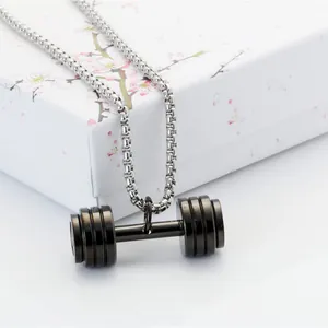 Industrial dumbbell pendant necklace with silver chain on floral gift box background