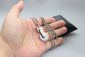 Vue détaillée du collier pendentif engrenage industriel en acier inoxydable poli à la main