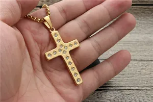 Close-up of golden cross pendant featuring sparkling inlaid stones on a square link chain