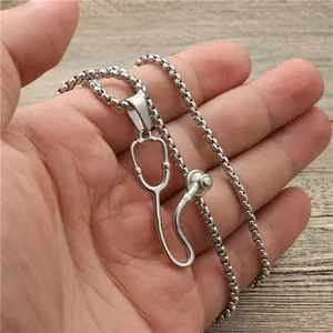 Silver stethoscope pendant necklace in stainless steel shown being held by hand