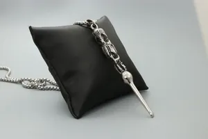 Macro detail of silver punk pendant featuring intricate carving on a black satin pillow