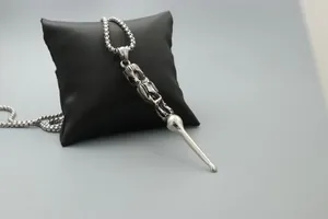 Macro shot of silver stainless steel pendant necklace with vintage relief carving details