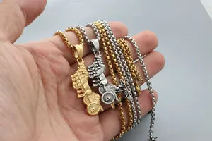 Détail de pendentifs calèche rétro dorés et argentés tenus dans la main
