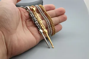 Close-up of gold and silver titanium steel ear pick pendants on sturdy box chains