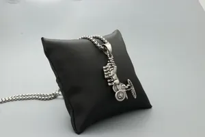 Vue détaillée du pendentif carrosse argenté sur un coussin de bijoux en satin noir