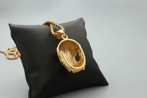 Vue détaillée du dos d'un pendentif tête de mort doré sur un coussin noir