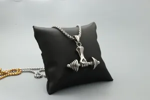 Macro view of hand clutching barbell pendant in silver finish on a black cushion