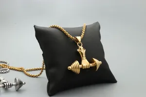 Detailed close-up of golden and silver dumbbell necklaces on a black jewelry pillow
