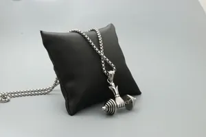 Detailed shot of a hand holding a dumbbell pendant on a box chain for fitness lovers