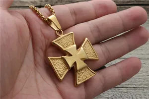 Macro view of golden Maltese cross pendant with hammered texture and circular box chain