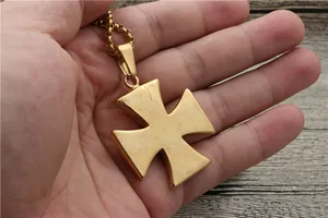 Close-up of vintage gold cross pendant with matte finish and robust chain necklace