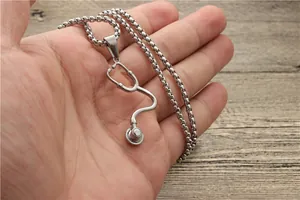 Detailaufnahme einer polierten Stethoskop-Halskette in Silber, die in der Hand gehalten wird