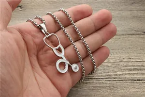 Detailaufnahme der silbernen Stethoskop-Halskette mit Stein und feiner Box-Kette