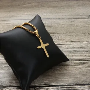 Poliertes Goldkreuz-Halsketten-Anhänger auf schwarzem Kissen mit Perlenkette