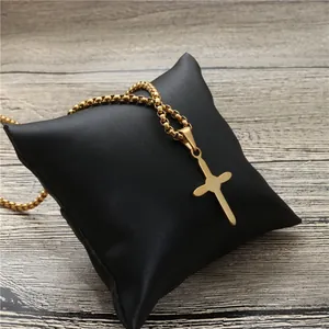 Modische goldene Kreuz-Halskette mit Box-Kette auf einem schwarzen Satinkissen