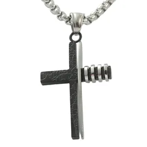 Détail macro du pendentif croix punk bicolore noir et argent avec gravure et texture gravée