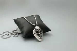 Detail of gothic skull shield pendant with vintage finish on black display pillow