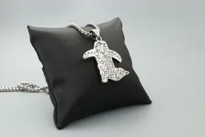 Detail of silver cowboy boot pendant with floral relief and industrial ball chain