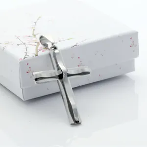 Colgante de cruz plateado pulido con caja de regalo de flores de cerezo sobre blanco
