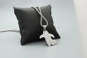 Close-up of a silver turtle pendant with intricate floral engravings on a leather pillow