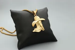Detailed close-up of golden western cowboy boot and hat pendant on a jewelry display