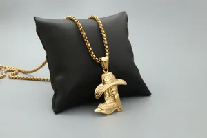 Detailed macro view of a golden cowboy hat and boot pendant with a polished box chain