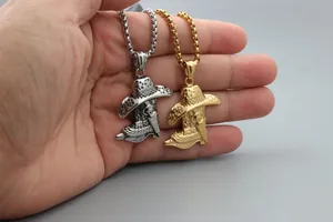 Detail of gold and silver cowboy hat and boot pendants on chains held in hand