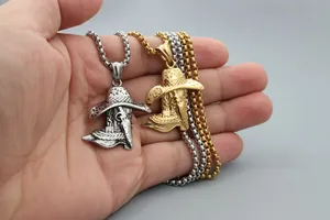 Detailed close-up of cowboy hat and boot pendant with gothic mask on a box chain