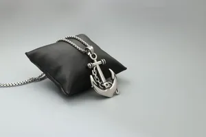 Détail du pendentif ancre en acier inoxydable 316L sur un coussin en satin noir