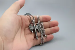 Macro shot of double-headed axe pendant with detailed scale textures on a box chain
