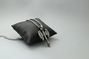 Detailed macro view of vintage stainless steel double-sided axe pendant on a black pillow