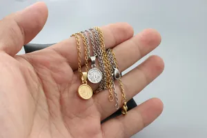 Detail of gold and silver necklaces featuring round pendants with vintage floral patterns